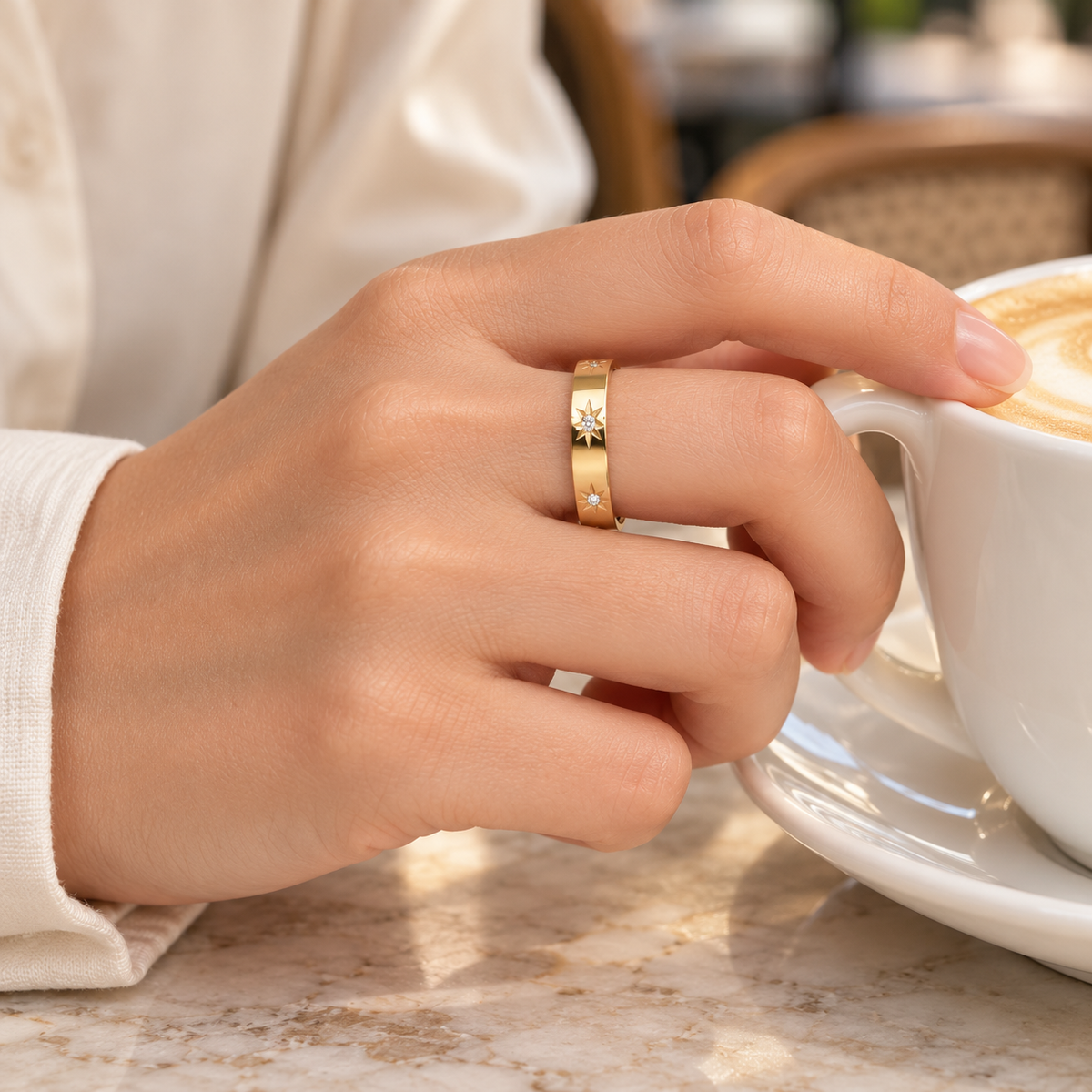 Anillo Amazonas dorado puesto en una mano sosteniendo una taza