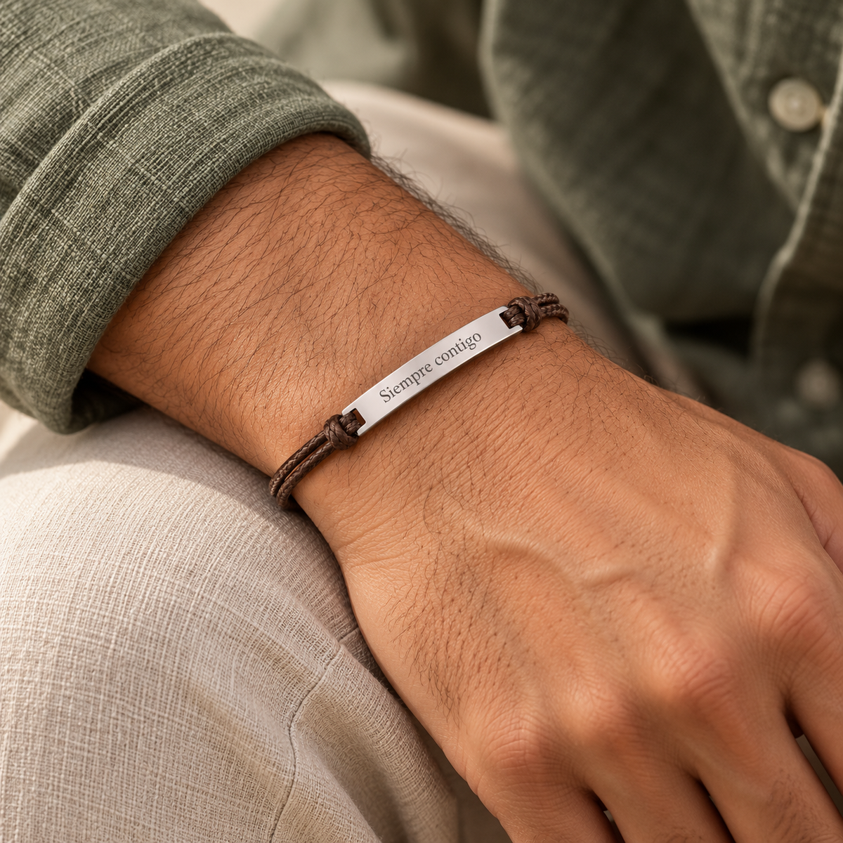 Pulsera Bali plateada con cordón café y grabado Siempre contigo en muñeca